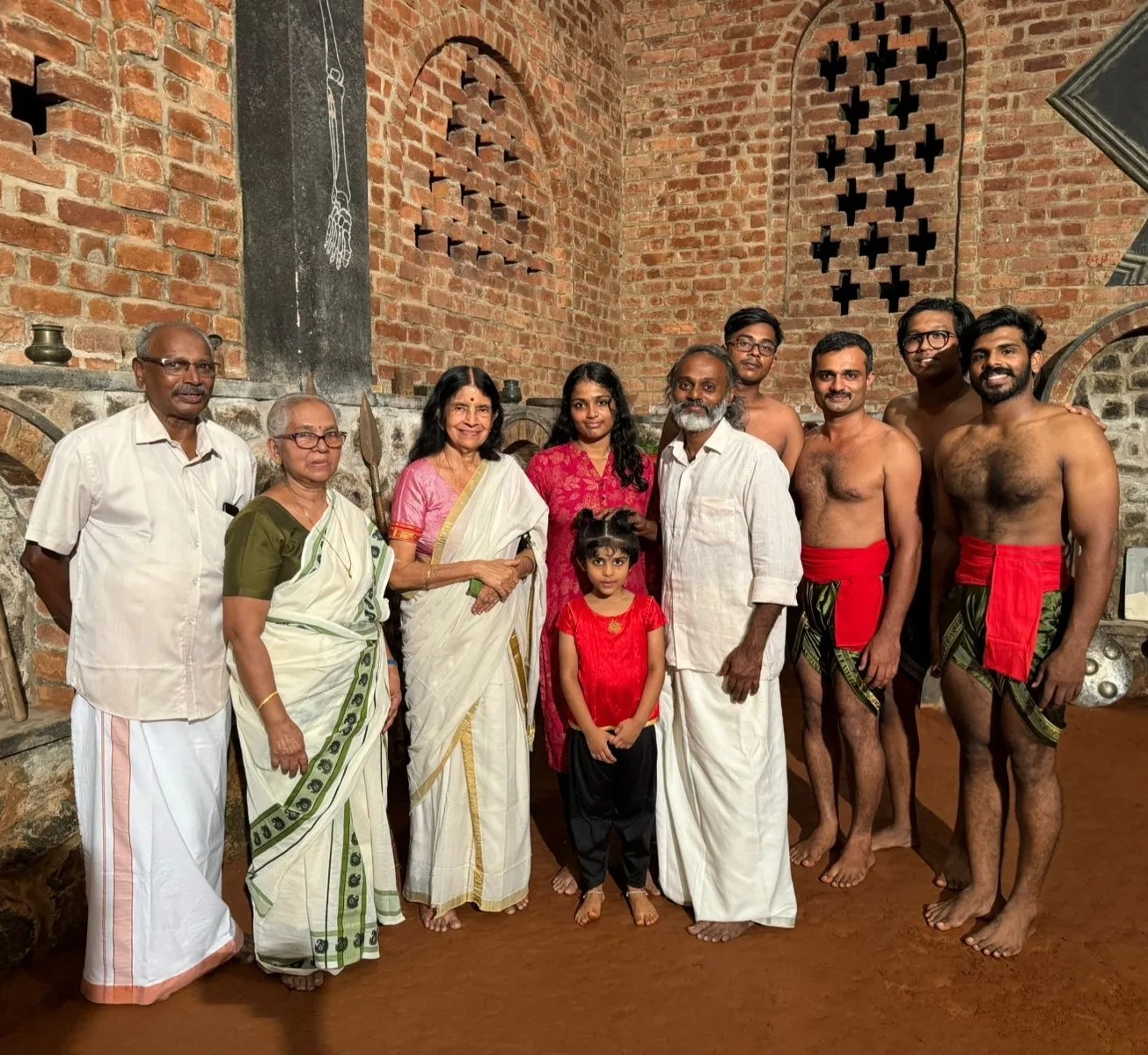 Multi-generational family group at Buddha Kalari showing traditional Kerala martial arts community and cultural heritage