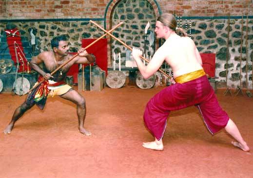 Traditional Kalaripayattu sword fighting between practitioners in authentic Kerala costumes showcasing weapon combat skills